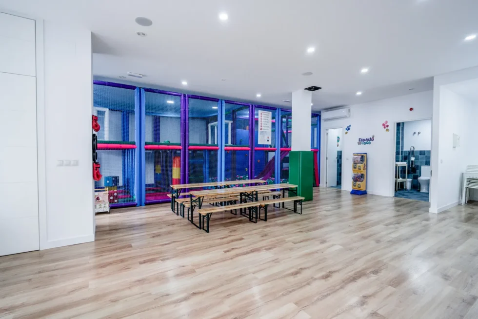 Sala de Espacio Loco limpia y recogida, con las mesas y el parque al fondo