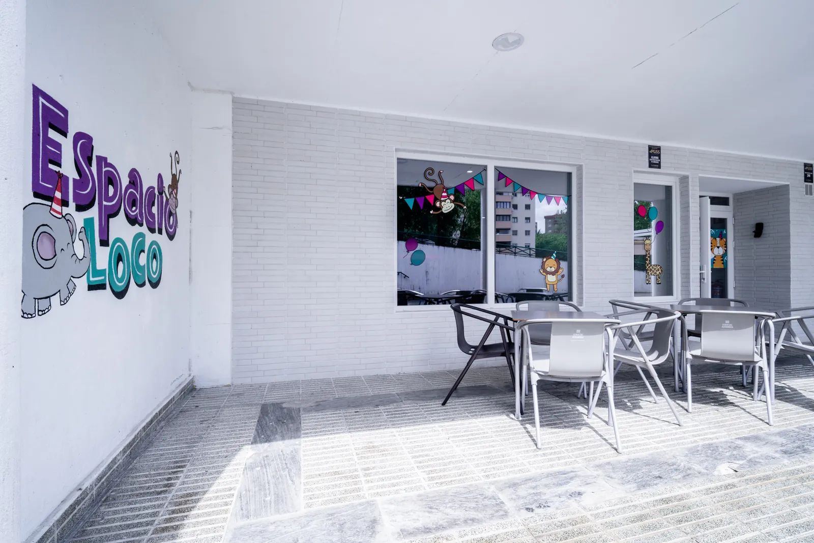 Terraza bajo los soportales con mesas y sillas